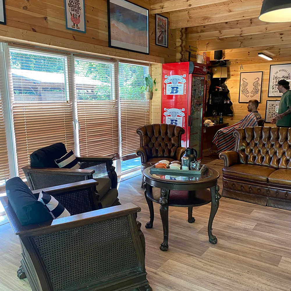 Lounge mit Ledersesseln und Chesterfield-Sofa im Holzhaus von Taubert's